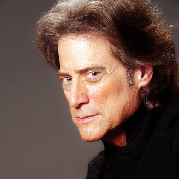 Promo photo of Richard Lewis regarding the viewer with apprehension and suspicion